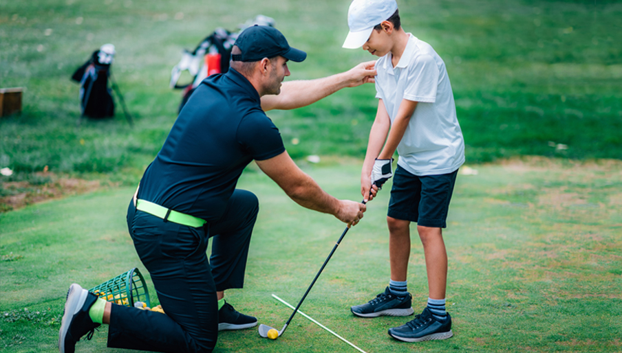 junior golfer getting instruction